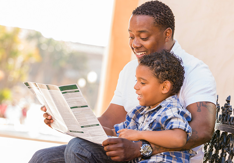 father son reading brochure